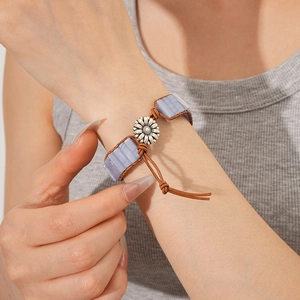 Dettaglio del bracciale vintage in pelle con pietra blu e chiusura in metallo a girasole
