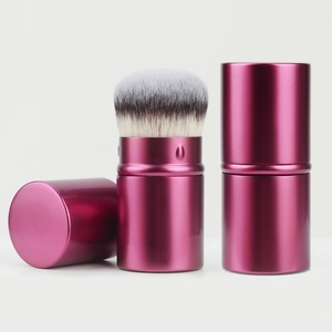 Detail view of pink retractable makeup brush with bristles, cap and closed state