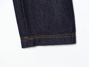 Close-up of deep blue denim cuff featuring durable orange double stitching and twill texture