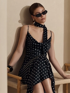 Close-up of black polka dot slip dress with matching skinny scarf in soft satin fabric