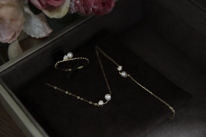 Detail of 18K gold S925 silver bracelet and ring set with pearls in a velvet gift box
