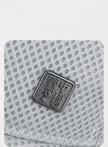 Macro shot of 3D embossed metal badge with Chinese characters on breathable mesh cap