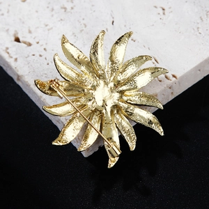 Detailed back view of the golden sunflower brooch showing pin fastener and metal texture