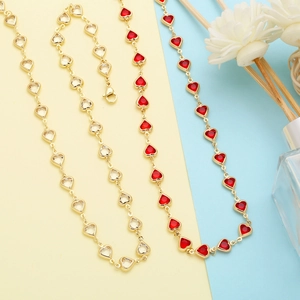Detail showing heart-shaped zircon necklaces in gold finish with red and clear stones