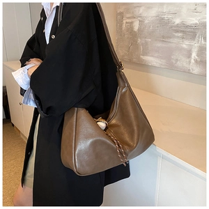 Detail of dark brown vintage faux leather tote bag with stylish braided tassel accents