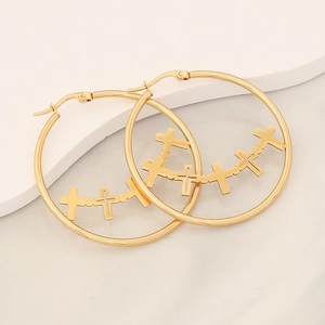 Detailed macro view of gold hoop earrings with nested cross motifs and secure clasp