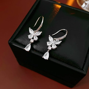 Vue macro de boucles d'oreilles papillon en zircon avec pierres en poire et fini argenté