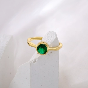 Irregular wave gold-plated copper ring with green zircon stone on silk and stone