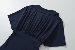 Détail de la robe à volants bleu marine avec col au dos et plis délicats