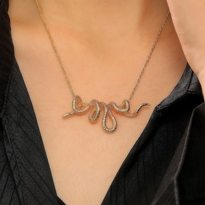 Close-up of a golden snake wrap necklace showing detailed serpent scales on neck