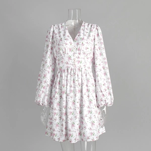 Detailed view of the deep V-neckline and button accents on floral lantern sleeve dress
