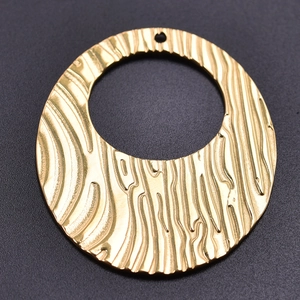 Detail of a textured golden 304 stainless steel oval pendant with wavy surface