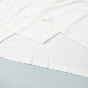 Détail de la couture à double aiguille sur l'ourlet d'une robe sirène en satin blanc