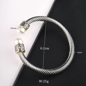 Macro shot of cable wire bracelet with 10mm pearls and vintage engraved details