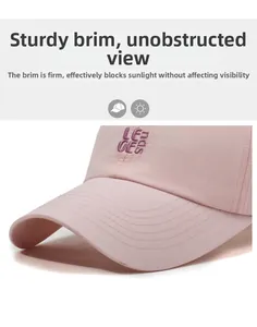 Detailed view of pink baseball cap with purple LE GEE embroidery and reinforced stitching