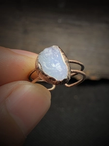 Macro shot of handmade vintage blue raw gemstone ring with woven bronze adjustable band