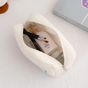 Interior detail of white plush makeup bag showing spacious storage for brushes and skincare