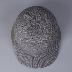 Vue détaillée du bonnet en maille gris foncé avec visière courte et texture fine