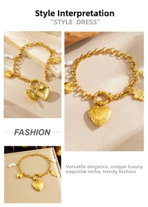 Close-up of gold heart locket and baroque pearl charms on a chunky curb chain bracelet