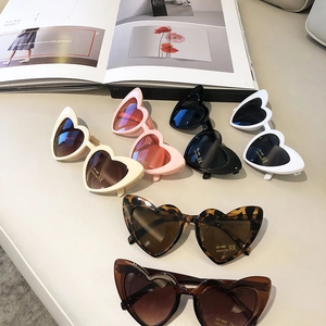 Detailed close-up of heart-shaped kids sunglasses in various colors with UV400 protection