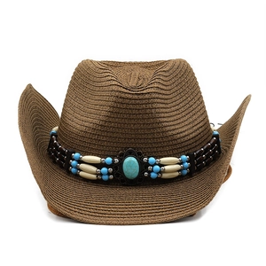 Detail of western straw hat with bohemian turquoise beaded band on woven texture