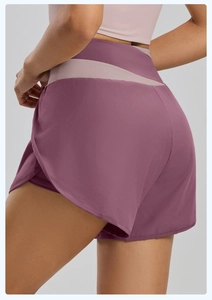 Détail du short de yoga violet prune à taille haute avec ceinture rose contrastée