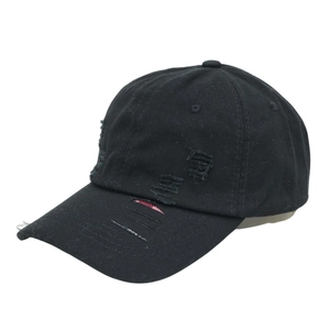 Detail der schwarzen Baseballkappe mit Rissen am Schirm und rotem Karofutter