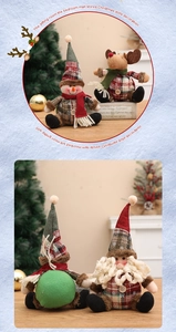 Detail of plush Christmas gnomes with plaid fabric and scarves on a festive wooden surface