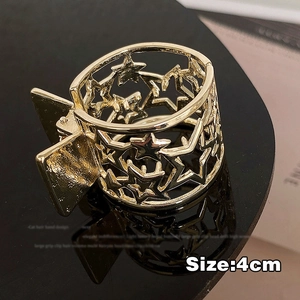 Detailed macro view of 4cm gold metal star cut-out hair claw clip for high ponytail