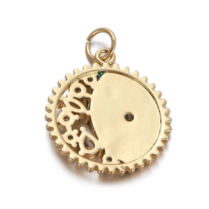 Detailed macro view of a gold-plated gear-edge pendant with hollow patterns and a brown gem