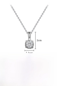Macro shot of silver pendant with square diamond halo and round center zircon on chain