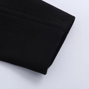 Dettaglio della manica del cappotto di lana nera con cuciture e trama del tessuto