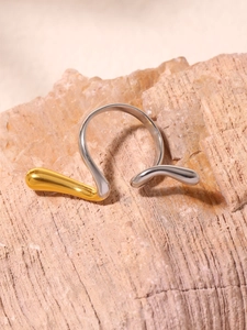 Macro shot of irregular mixed metal ring on textured stone showing gold and silver finish