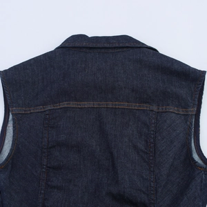 Détails du dos d'un gilet en jean bleu foncé avec surpiqûres contrastées et empiècement