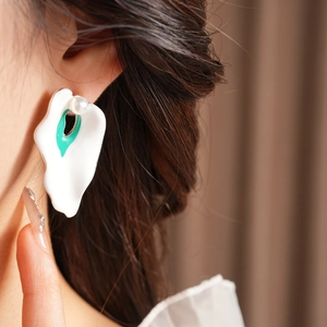 Close-up of model wearing enamel flower earrings with pearls in organic shape