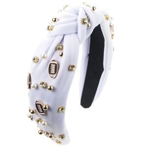 Detail eines weißen geknoteten Haarreifs mit Perlen, Strass und Football-Anhängern