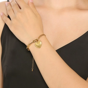 Close-up of 18K gold-plated heart pendant bracelet on wrist with sunburst texture detail