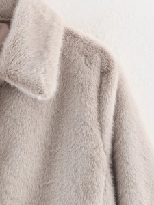Detail of soft faux fur texture and wide lapel design on short light beige winter coat