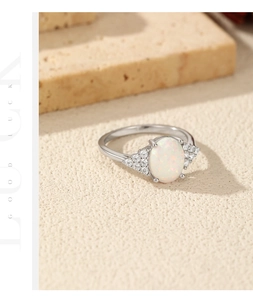 Close-up of S925 silver ring with oval opal stone and side zircon accents on white stone