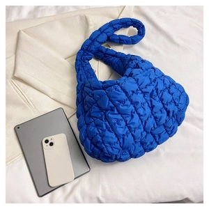 Blue quilted nylon puffy bag displayed with a tablet and mobile phone on white fabric