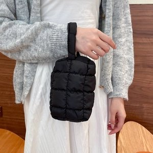 Close-up of black quilted nylon handbag featuring a soft padded diamond pattern texture