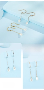 Detail of drop-shaped white pearl earrings with elegant long chain in gold and silver finish