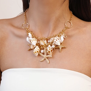 Detail showing gold double-layered necklace with natural seashell and starfish charms