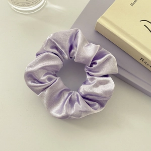 Detailed view of light purple satin scrunchie with a lustrous silk finish and soft pleats