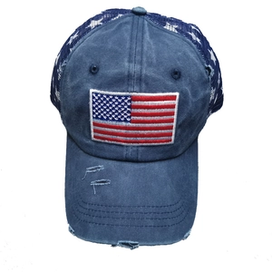 Detailaufnahme der US-Flaggenstickerei und des Distressed-Schirms am Navy-Trucker-Cap