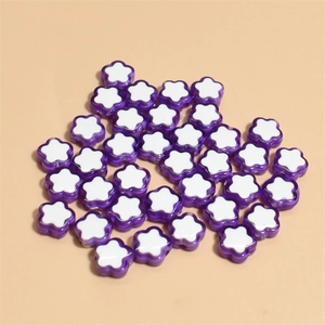 Dettaglio macro di perline a fiore da 10 mm con bordi viola traslucidi per fai-da-te