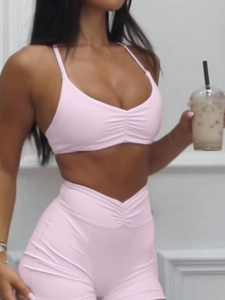 Detailansicht von rosa gerafftem Neckholder-Top und Sportshorts mit hoher Taille