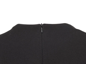 Gros plan de la fermeture éclair invisible au dos de cette robe courte noire ajustée