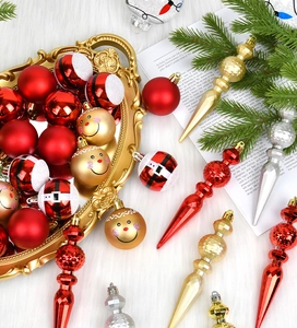 Detail of red and gold Christmas ornaments including baubles and icicles on plush fabric