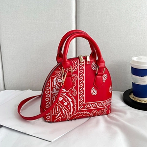 Fashionable red shell handbag with white paisley pattern and gold-tone hardware detail